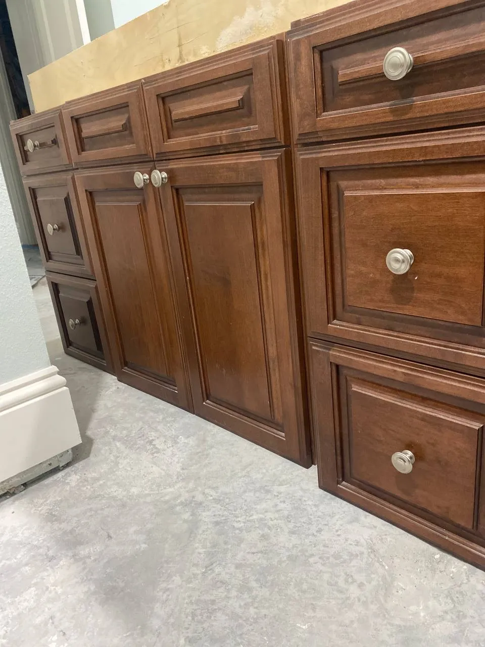 Dark wood kitchen base cabinets and an unfinished countertop during a remodel