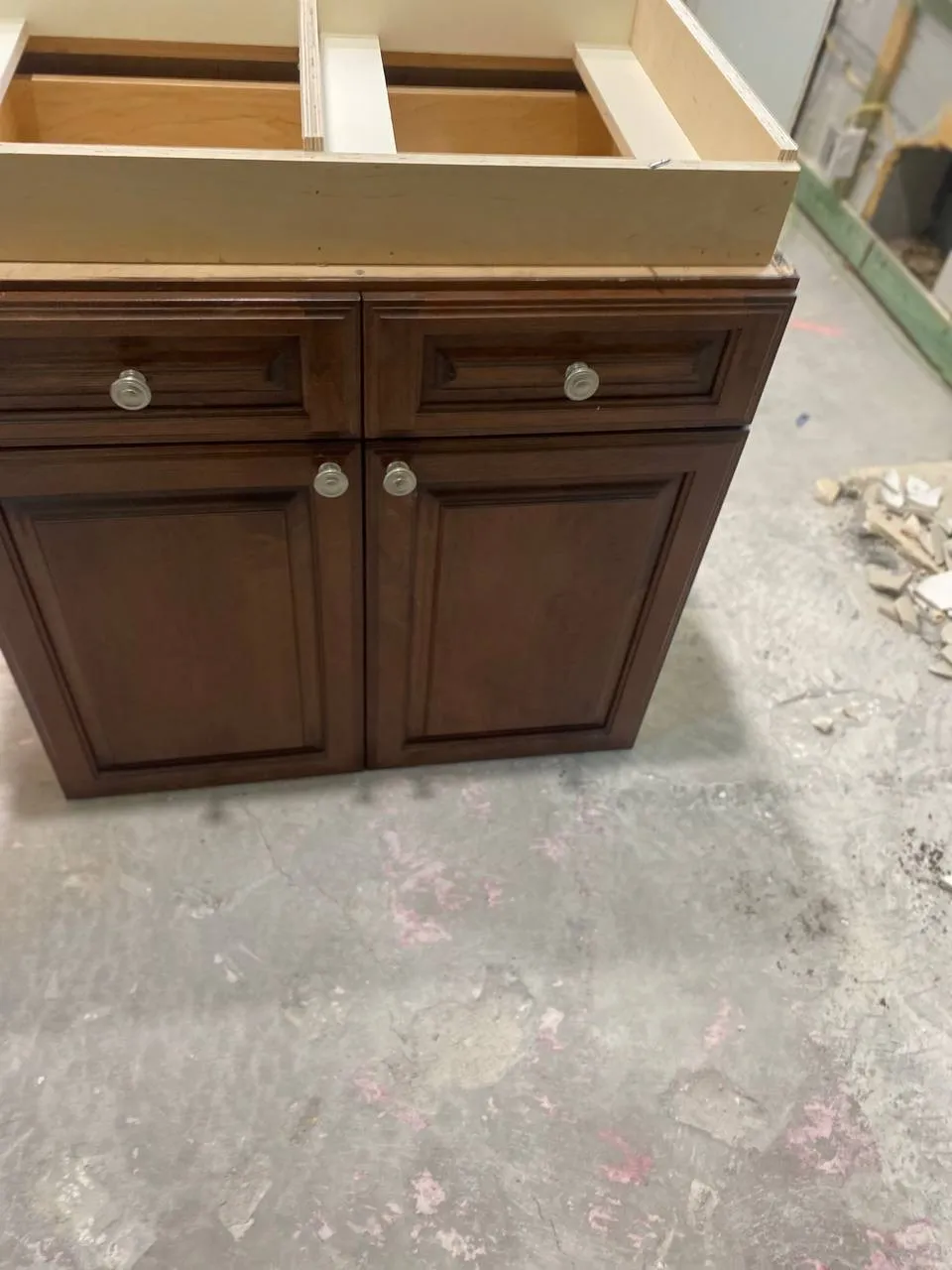 Dark wood bathroom vanity without a countertop during a remodel