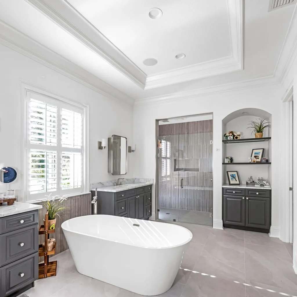 Remodeled bathroom with a double vanity, freestanding tub and walk-in shower
