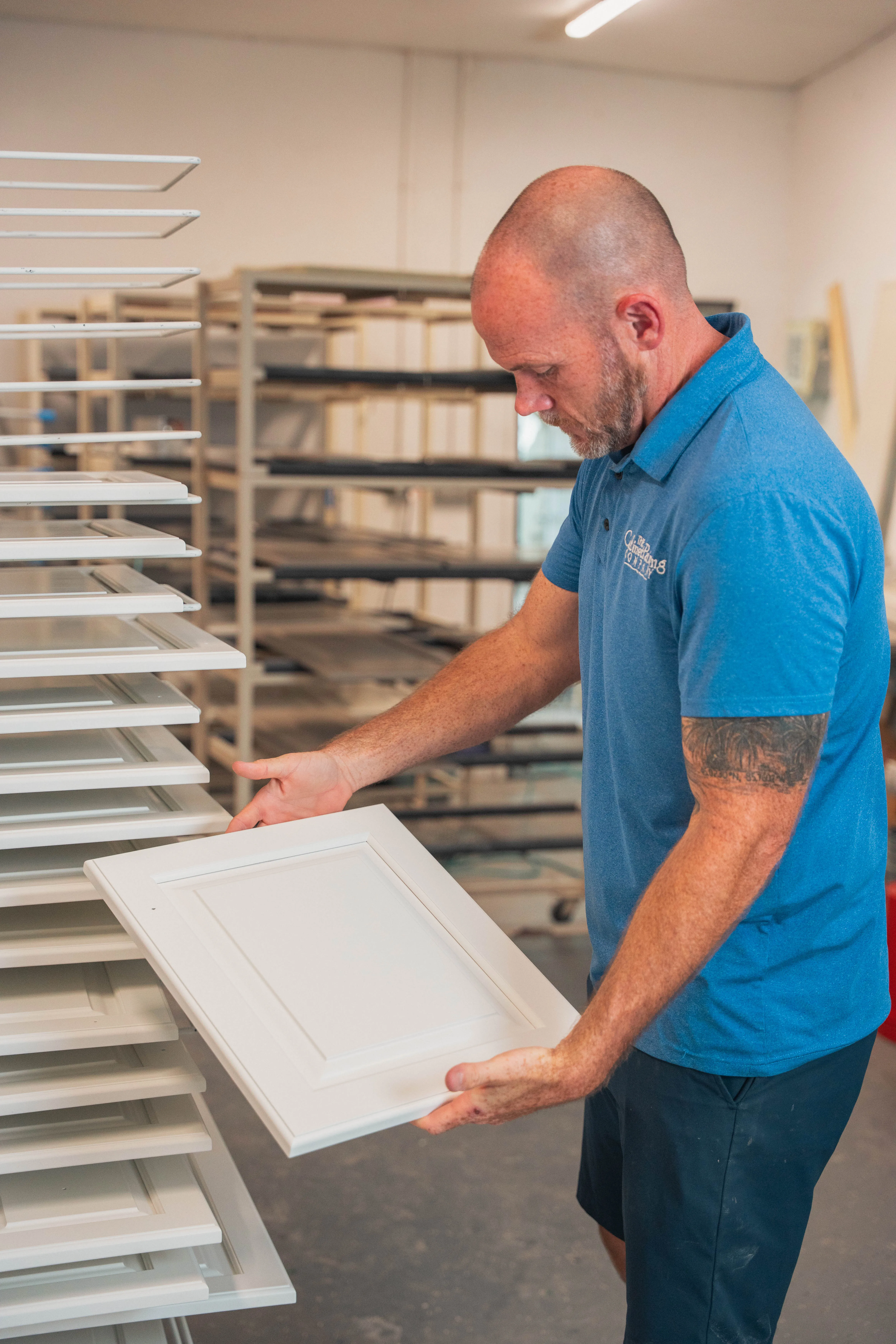 Brian Shaffer placing a finished cabinet door on a drying rack