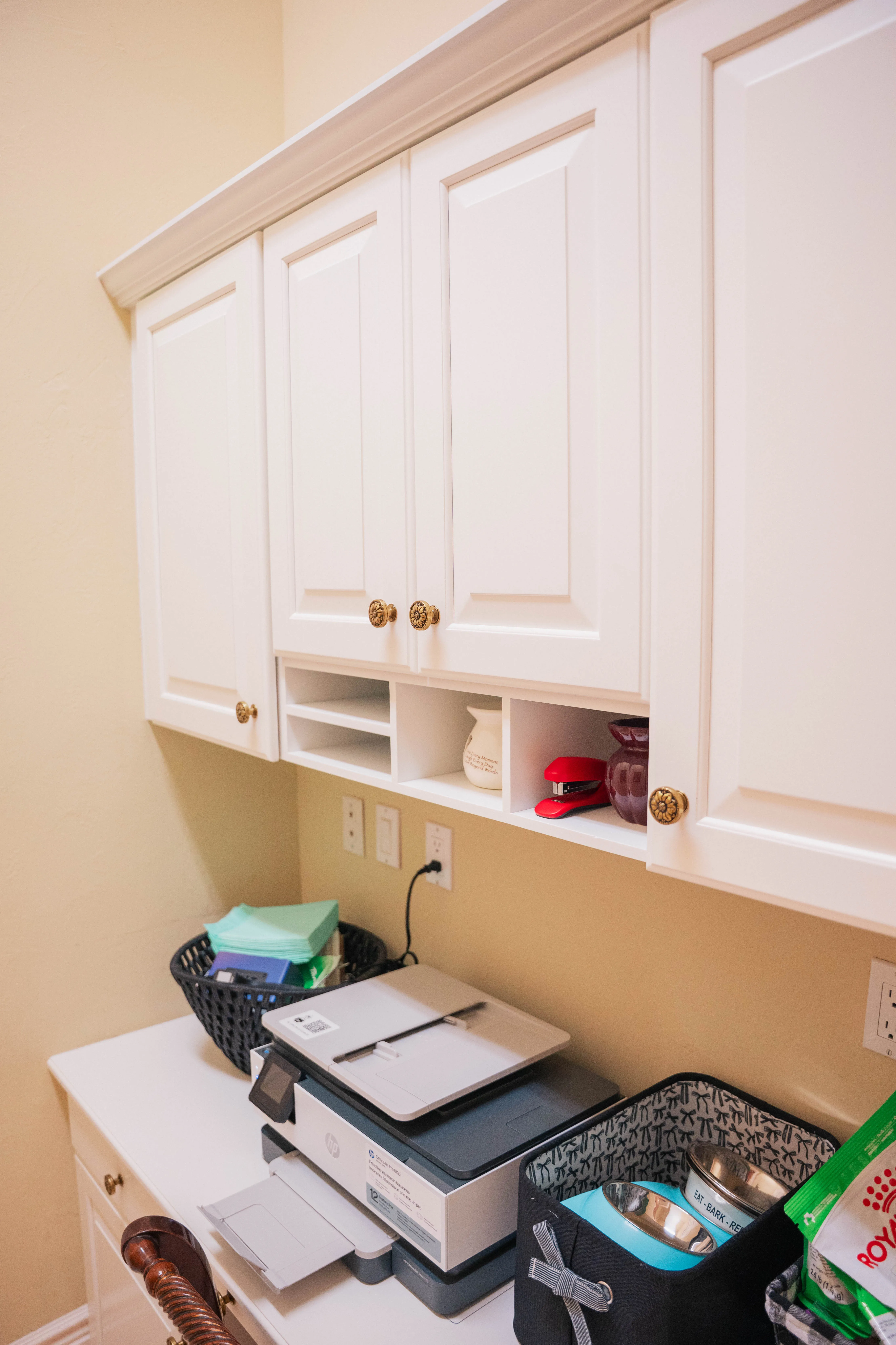 Refinished white upper cabinets and a built-in desk cubby