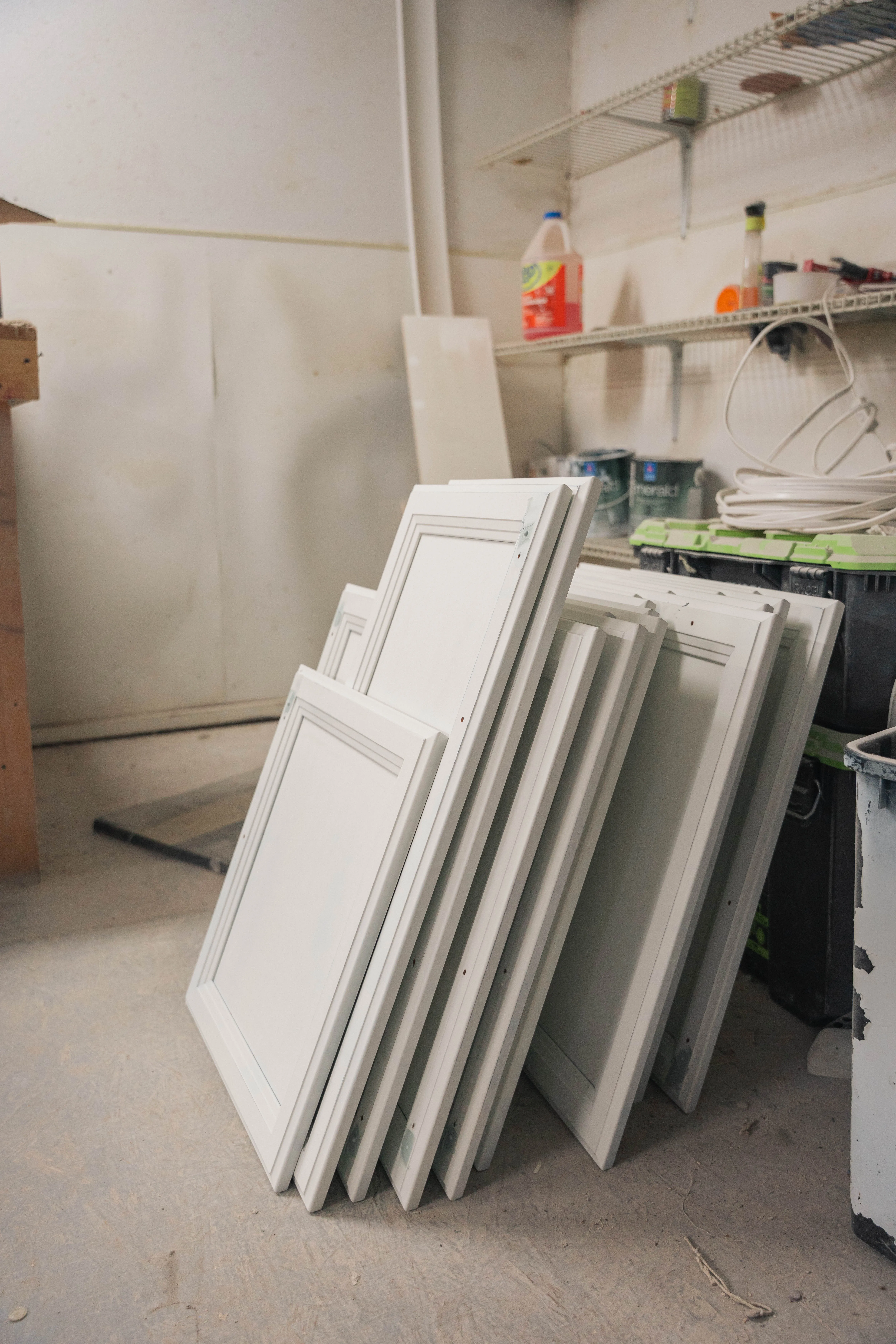Freshly painted white cabinet doors stacked to dry in the workshop