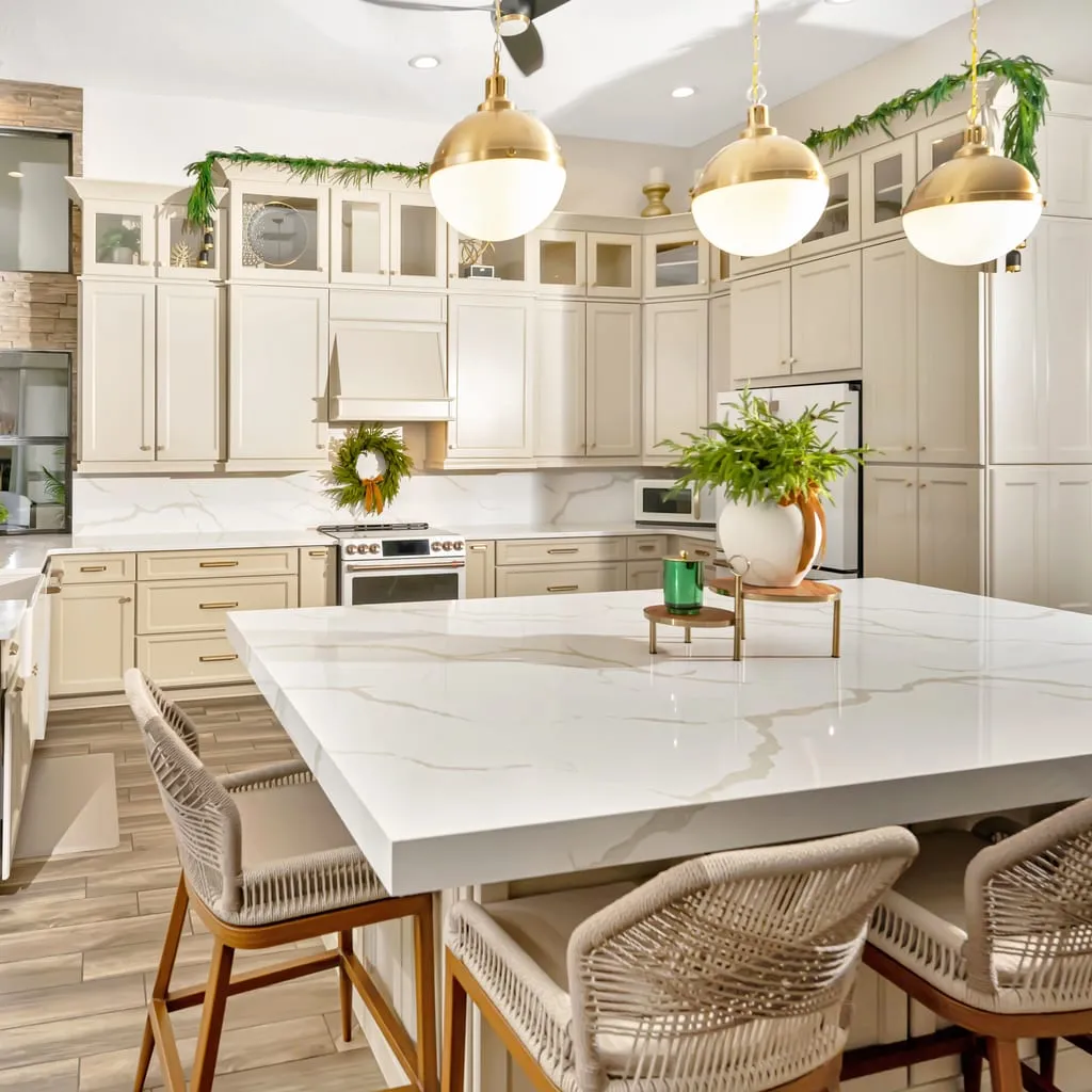 Kitchen with a waterfall quartz island and brass pendant lights