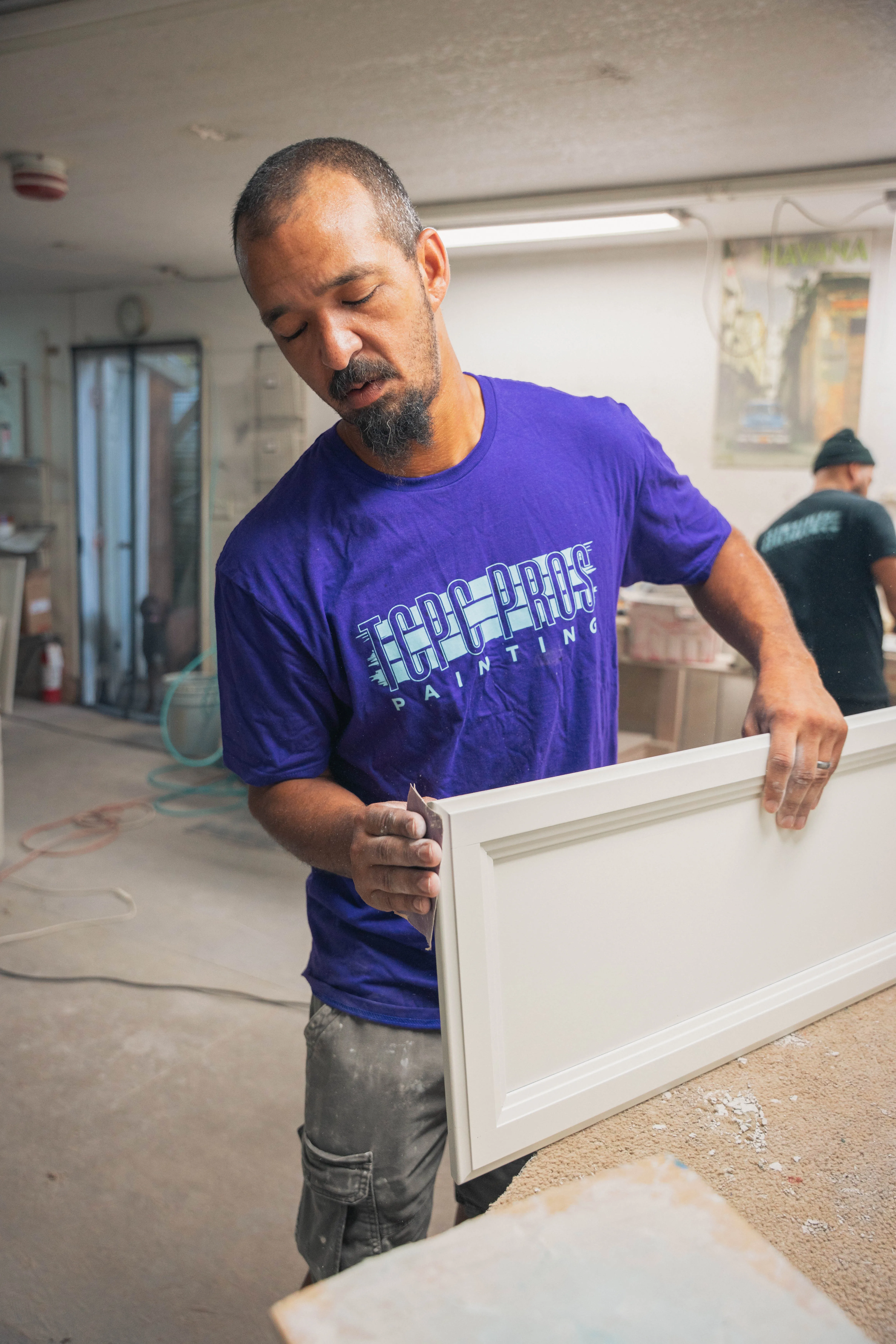 Sanding a cabinet door at the workbench