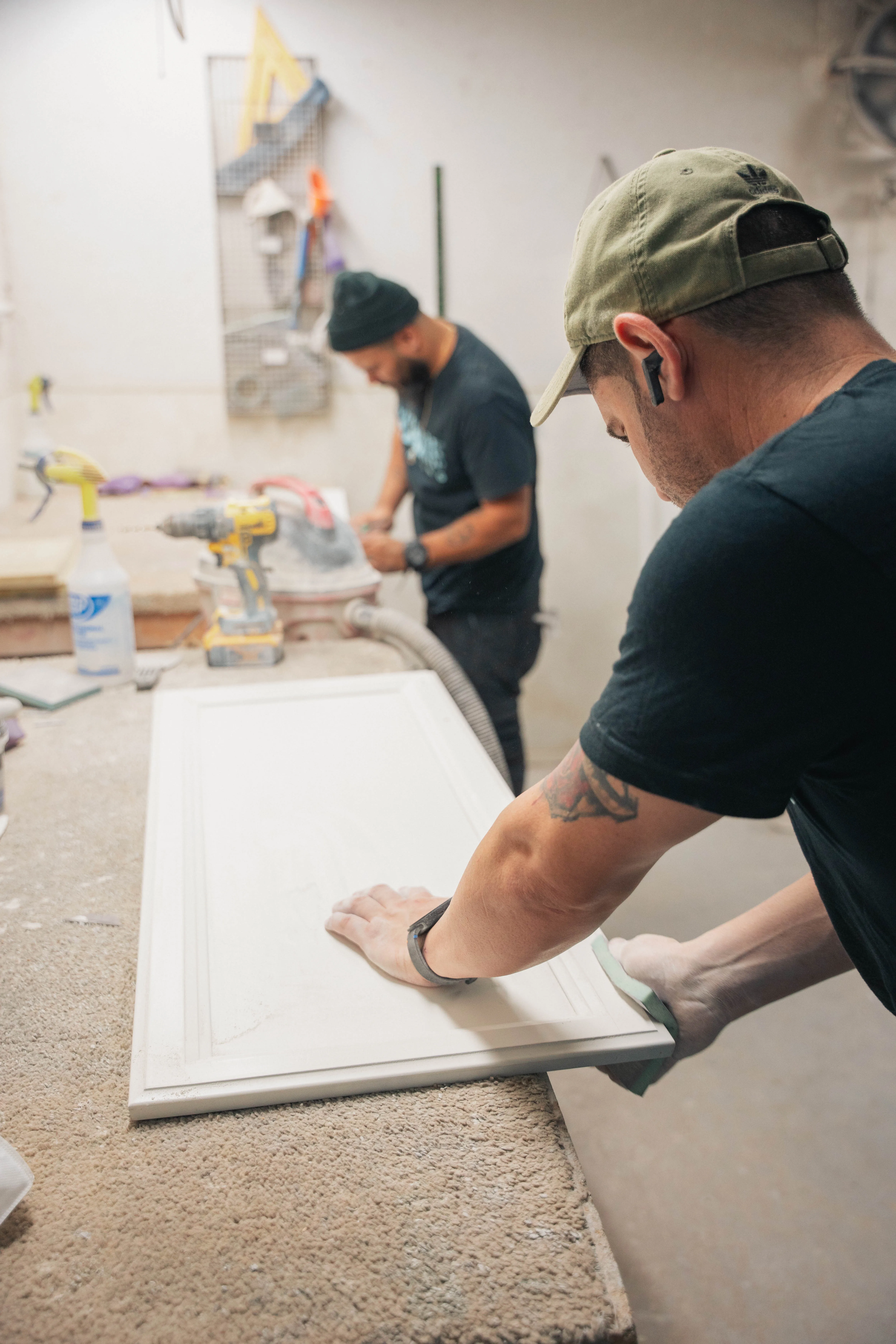 Hand-sanding a cabinet door before painting